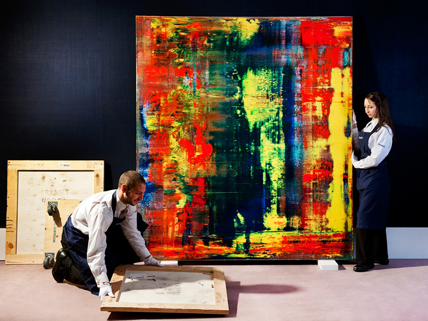 Gallery technicians hanging a picture by Gerhard Richter at Sotheby's