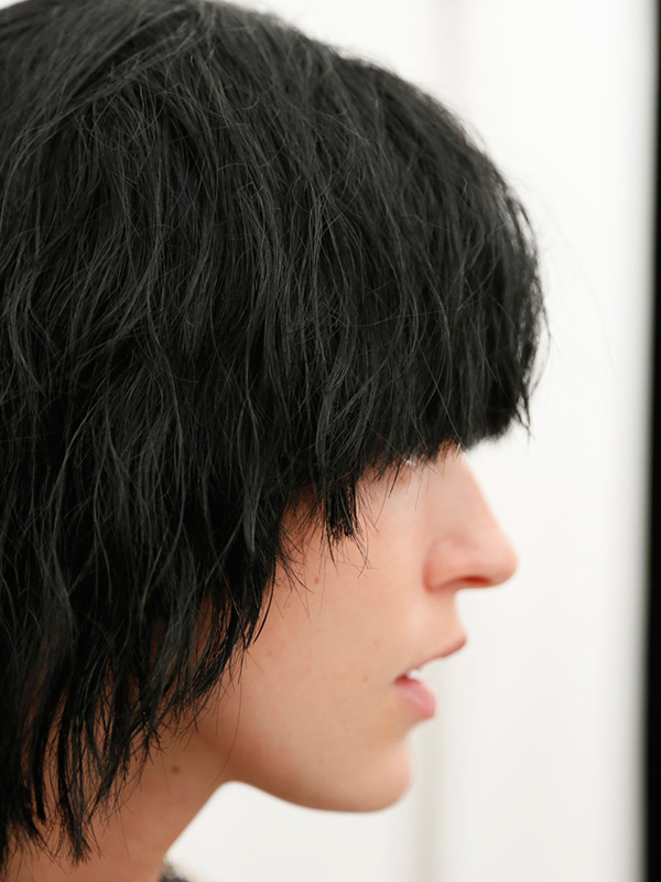 髮型師Guido Palau以凌亂微捲的黑色假髮，詮釋帶有搖滾風格的髮型。