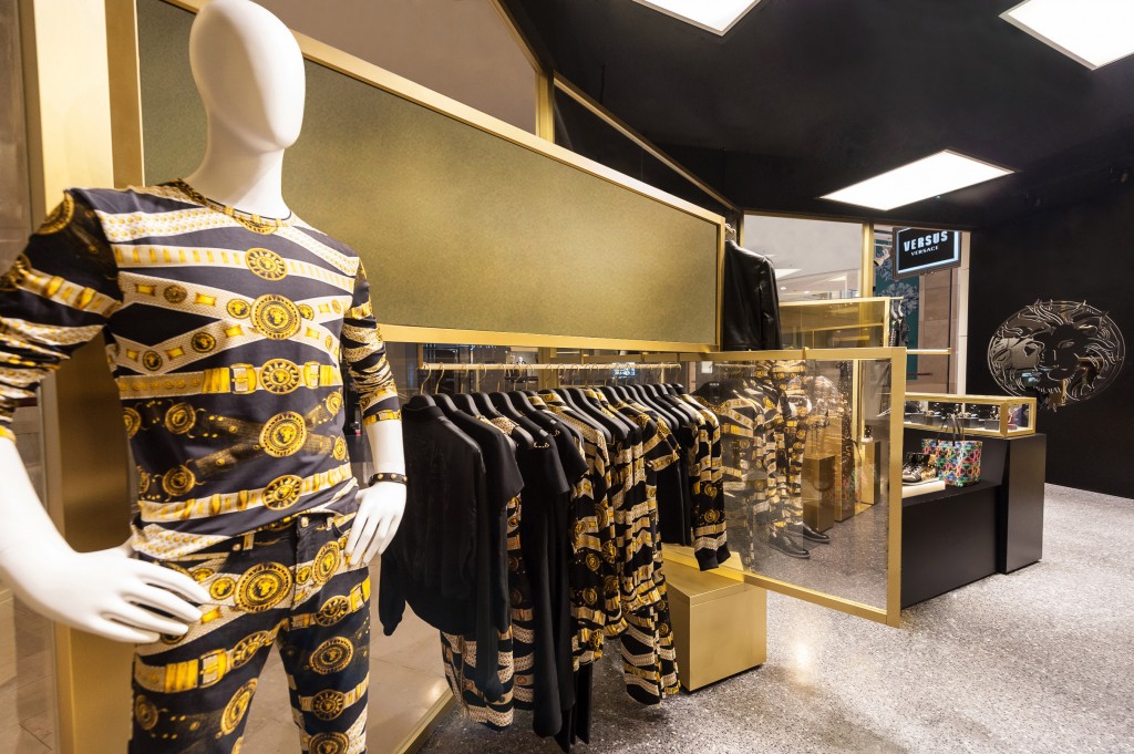 Versus Versace 位於101購物中心的全新概念店設計以金黃色銅架搭配雙面鏡，交互映照出店內多樣的商品款式。