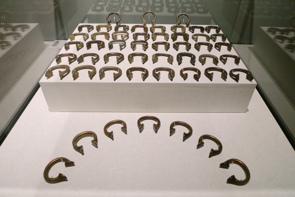 16世紀初，50枚馬蹄型手鐲等於一位非洲黑奴的身價。此等音譯為「馬尼拉（Manilla）」的物品為葡萄牙文「手鐲」之意，曾因內含銅的成份而受到非洲各國珍視。馬蹄型鐲體積大者，嘗穿戴於身上，作為財富的象徵。馬蹄型手鐲多於歐洲製造，用供與當地商賈交易不同貨物，包括戰俘與遭綁架之俘虜等。馬蹄型手鐲的價格起伏不定，不同港口對各類馬蹄型手鐲的接受度亦不盡相同。此處所見之馬蹄型手鐲，體積不大，又稱「奧克波赫（Okpoho）馬尼拉斯」，出土於曾為主要奴隸交易中心的奈及利亞。