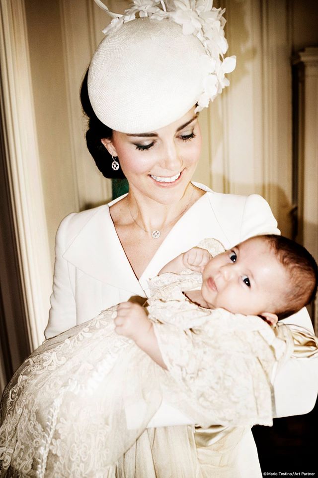 穿著Alexander McQueen象牙白套裝的凱特王妃，優雅抱著夏綠蒂小公主。(Photo by Mario Testino)